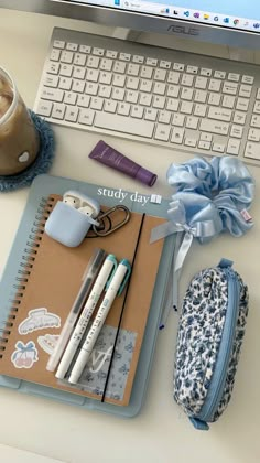 a laptop computer sitting on top of a desk next to a cup of coffee and pencils