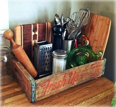 a wooden crate filled with kitchen utensils and cooking utensils on top of a table