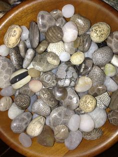 a wooden bowl filled with lots of rocks