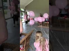 two girls in pink dresses are walking down the hall with balloons all over their body