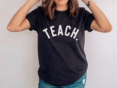 Retro Teach Shirt, Retro Teacher Shirt, Teacher Raglan, Teach Shirt Teach Shirt Teacher Shirt, Homeschool Mom Shirt, Cute Shirt for Teachers Please read ordering details before purchasing Features *Soft and Comfy T Shirt *Unisex T Shirt *Double stitching neckline and sleeves *100% ring-spun cotton *Sport Grey is 90% ring-spun cotton, 10% polyester *Dark Heather is 65% polyester, 35% cotton *Pre-shrunk *Shoulder-to-shoulder taping *Quarter-turned to avoid crease down the centre Care Instructions *Machine wash cold inside out *Tumble dry low *Do not dry clean Colour Please note due to monitor display, colours may differ slightly from your screen compared to the final product. Sizes Please check your size carefully before ordering as each item is customised we do not accept exchanges. Measure School Spirit Tops For Back To School Teaching, Back To School Spirit Tops For Teaching, Casual Short Sleeve Shirt For Teaching, Casual Tops For Teaching, Back To School, Relaxed Fit Shirt For School With School Spirit, Relaxed Fit Shirt With School Spirit, School Spirit Letter Print Top, Casual Relaxed Fit Tops For Teaching, Fitted Pre-shrunk Tops For School