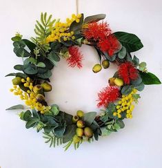 a wreath with flowers and leaves hanging on a wall