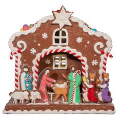 a gingerbread house with christmas decorations on the roof and people in front of it