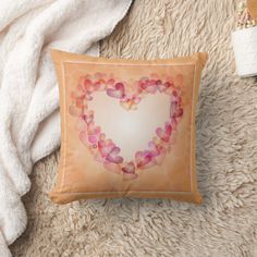 a heart shaped pillow sitting on top of a fluffy white rug next to a blanket