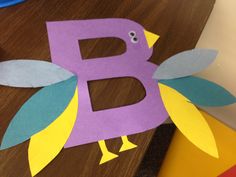 a paper bird sitting on top of a wooden table