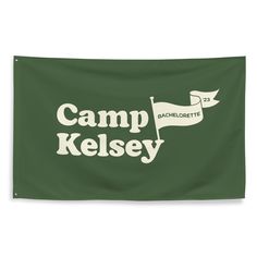 a green banner with the words camp kelsey in white on it's left side