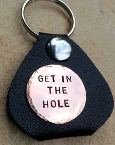 a keychain that says get in the hole on it