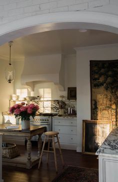 a kitchen with an archway leading into the dining room