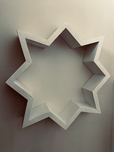 a white star shaped object hanging on the wall