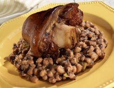 a yellow plate topped with meat and beans