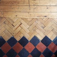 the floor is made out of wood and has black, red and white tiles on it