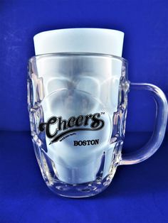 a clear glass mug with the word cheers on it's side and boston written in black