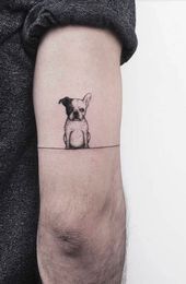 a small dog tattoo on the arm