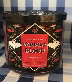 a candle that is sitting on a checkered tablecloth with the words vampire blood