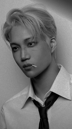 a young man with blonde hair wearing a shirt and tie, posing for a black and white photo