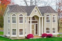 a small white house sitting on top of a lush green field