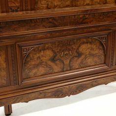 an antique wooden dresser with carvings on the front and sides, inlaid to wood