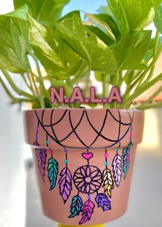 a potted plant with leaves painted on it and the word nala above it