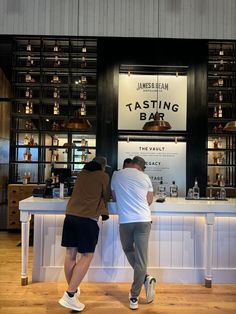 two men standing at a counter in front of a tasting bar