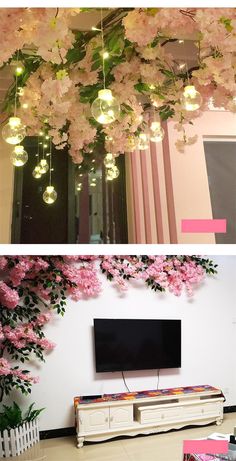 pink flowers are hanging from the ceiling and on the wall in front of a flat screen tv