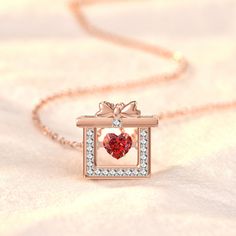 This gift box pendant is the perfect finishing touch to any look! The CZ-studded red heart is the ideal way to add shine to your favorite outfit. Available in rose gold and silver tones. Valentine's Day Jewelry With Gift Box, Heart-shaped Jewelry For Valentine's Day With Gift Box, Heart Jewelry With Gift Box For Anniversary, Heart-shaped Jewelry With Gift Box For Anniversary, Heart Jewelry In Gift Box For Anniversary, Rose Gold Jewelry In Gift Box For Birthday, Heart-shaped Jewelry Gift Box For Anniversary, Elegant Jewelry Gift Ready For Birthday, Elegant Birthday Gift Jewelry, Gift Ready