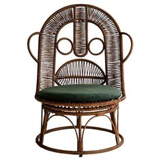 a wicker chair with a green cushion on the seat and backrest, in front of a white background