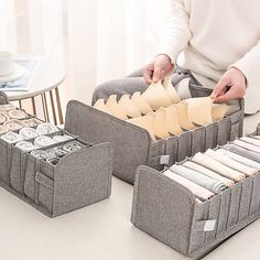 a person sitting on the floor next to two storage bins with money in them