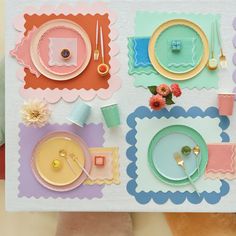 a table set with place settings and flowers