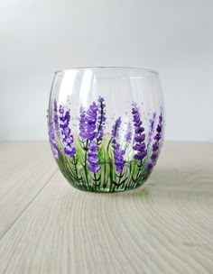 a glass with purple flowers painted on it