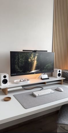 a flat screen tv sitting on top of a white desk next to a keyboard and mouse