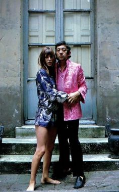 a man and woman standing in front of a door with their arms around each other