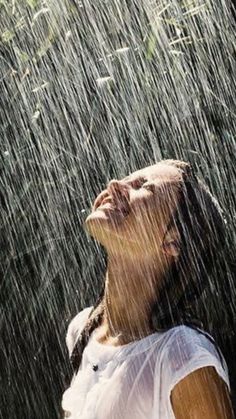 a woman standing in the rain with her eyes closed