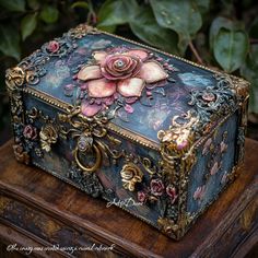 an ornately decorated box sitting on top of a wooden table