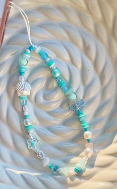 a blue and white beaded necklace sitting on top of a plate