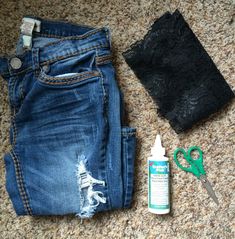 a pair of jeans, lace and scissors are on the floor next to an empty bottle