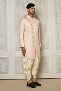 Baby pink sherwani with all over floral mandala pattern. Paired with cream dhoti pant.
Components: 2
Pattern: Woven
Type Of Work: Floral Mandala
Neckline: Stand Collar
Sleeve Type: Full Sleeves
Fabric: Sherwani: Jaquard, Dhoti Pant: Cotton Silk
Color: Pink
Other Details: 
Closure: Front buttons
Embellished brooch detailing
Asymmetric hem
Occasion: Sangeet - Aza Fashions Pink Sherwani For Diwali And Traditional Ceremonies, Pink Sherwani With Zari Work For Traditional Ceremonies, Pink Sherwani For Traditional Ceremonies And Eid, Pink Sherwani For Festive Traditional Ceremonies, Festive Pink Sherwani For Traditional Ceremonies, Pink Sherwani With Pallu For Traditional Ceremonies, Traditional Pink Sherwani For Navratri, Traditional Pink Raw Silk Sherwani, Pink Fitted Kurta For Traditional Ceremonies