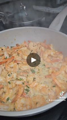 a pan filled with pasta and shrimp on top of a stove