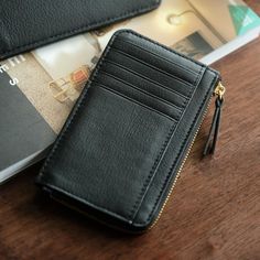 a black wallet sitting on top of a wooden table