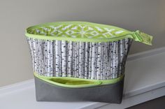 a green and white storage bag sitting on top of a shelf next to a window