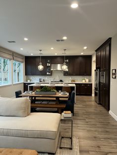 a living room filled with furniture next to a kitchen and dining room table in front of a window