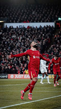 a soccer player in the air with his arms outstretched and head tilted to the side