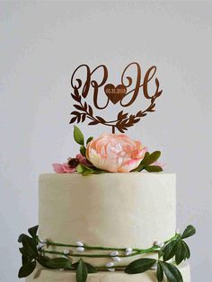 a wedding cake topped with a white frosted cake topper and a pink flower