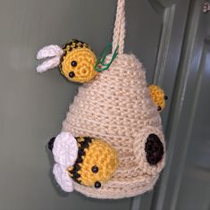 two stuffed animals hanging from a hook on a door handle, one is yellow and the other is white