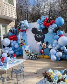 a mickey mouse balloon arch is decorated with balloons