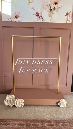 the diy dress up rack with flowers on it in front of a pink wall