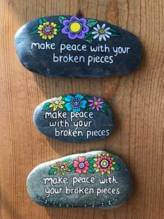 three rocks with words painted on them