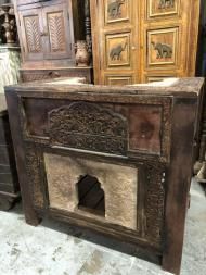 an old looking wooden cabinet with carvings on the top and bottom, in front of other antique furniture