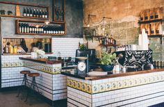 the interior of a restaurant with tiled counter tops and bar stools in front of it