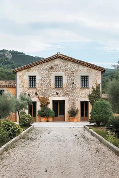 an old stone house surrounded by greenery and trees