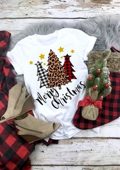 a white shirt that says merry christmas with trees on it and plaid stockings next to other items